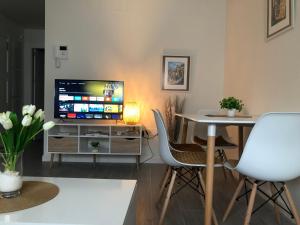 sala de estar con TV, mesa y sillas en Apartamento Air Blanc Maracena Centro, en Maracena