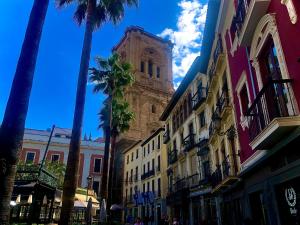 ein hohes Gebäude mit einem Uhrturm auf einer Straße in der Unterkunft Apartamento Air Blanc Maracena Centro in Maracena