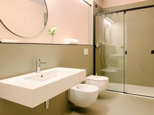 a bathroom with a sink and a toilet and a mirror at Villa Verlengia in Montesilvano