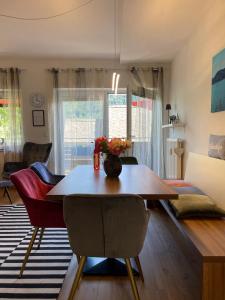 uma sala de estar com uma mesa de madeira e cadeiras em Seewohnung Lucia - mit Seezugang em Annenheim