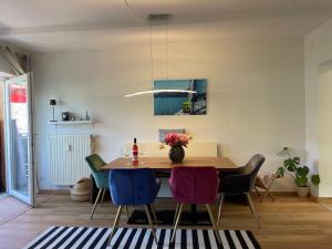 comedor con mesa de madera y sillas en Seewohnung Lucia - mit Seezugang, en Annenheim