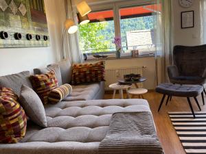 sala de estar con sofá y ventana en Seewohnung Lucia - mit Seezugang, en Annenheim