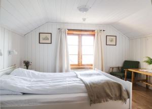 a white bed in a room with a window at Glomstad Gjestehus in Tretten