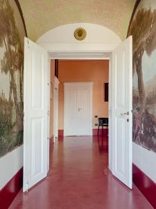 an empty hallway with white doors and paintings on the walls at Villa Verlengia in Montesilvano