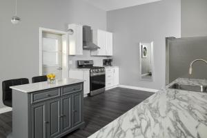 a kitchen with white cabinets and a counter top at Samuels Boutique Hotel in Goderich