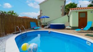 basen na dziedzińcu z krzesłami i parasolem w obiekcie Villa Nicolara by Rent Istria w mieście Buzet