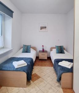 a room with two beds with towels on them at Apartament Riviera z widokiem na kanał Augustowski in Augustów