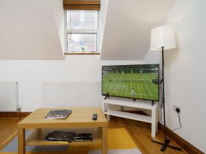 a living room with a flat screen tv and a table at Flat in London in London