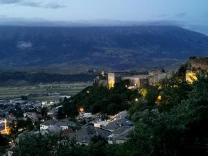 a city with a castle on a hill at night at Stone rooms 1850 in Gjirokastër