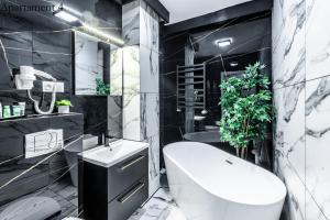 - une salle de bains en noir et blanc pourvue de toilettes et d'un lavabo dans l'établissement Apartamenty Katowice by Lantier - Bytom - Chorzów, à Bytom