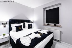 a bedroom with a bed with two towels on it at Apartamenty Katowice by Lantier - Wellness & Spa in Bytom +122 photos