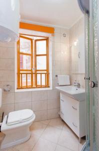 łazienka z toaletą, umywalką i oknem w obiekcie Top City Center Apartments w Szybeniku