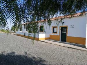 a white building with a black door on a street at A casa da Carolina II in Mértola