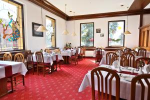 - une salle à manger avec des tables, des chaises et des fenêtres dans l'établissement Parkhotel Wörlitz, à Oranienbaum-Wörlitz