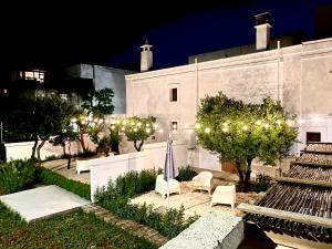 a building with a yard with chairs and lights at Villa Ricciardi-Suite famigliare 1-zona Ostuni in Montalbano