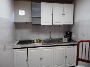 una cocina con armarios blancos y fregadero en Hermoso chalet en una muy buena ubicación, en Chía