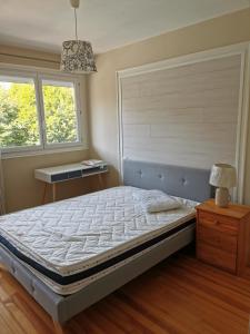 um quarto com uma cama, uma mesa e 2 janelas em Velay cocon appartement 4 chambres avec vue sur les monuments em Le Puy-en-Velay