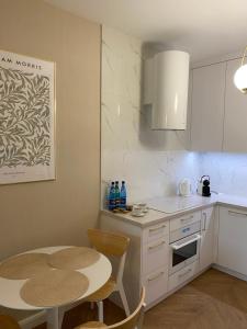 a kitchen with a table and a small table and a table and chairs at Apartament Powiśle Deluxe in Warsaw