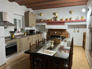 uma grande cozinha com uma mesa e um fogão em Casa Cueva La Fuente em Fontanar