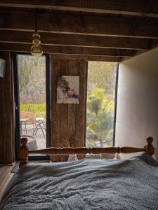 a bedroom with a bed and a large window at Panoramic Noah's Loft in Stînceni