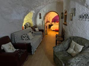FontanarにあるCasa Cueva La Fuenteのリビングルーム(ソファ付)、ベッドルーム(ベッド付)