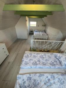 2 camas en una habitación con suelo de madera en Helló Zsóry Apartman, en Mezőkövesd
