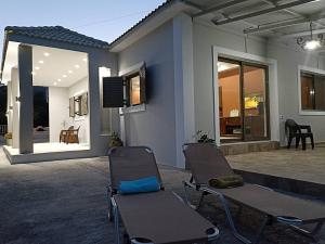 a pair of chairs in front of a house at Villa DimMar in Zakynthos Town