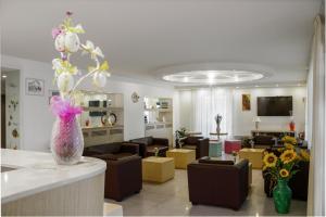 - un salon avec un vase orné de fleurs dans l'établissement Hotel Ilde, à Rimini