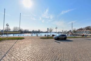 un coche aparcado en un estacionamiento junto a un cuerpo de agua en Karlshagen, Hafenidyll Fewo Dörte, en Ostseebad Karlshagen