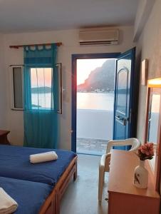 a bedroom with a bed with a view of the water at Ariadne Studios in Kalymnos