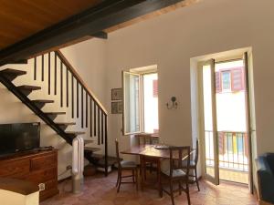 a dining room with a table and a staircase at La luce del borgo in Castel Gandolfo
