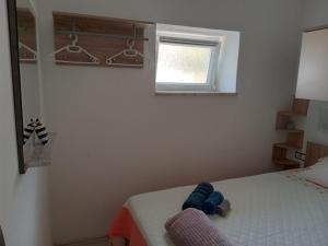 ein Schlafzimmer mit einem Bett mit einem blau ausgestopften Tier darauf in der Unterkunft Kastelanic apartman in Brbinj
