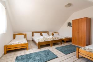 a room with two beds and two rugs at Szeparé pinceház szállás Villány központi részén. in Villány