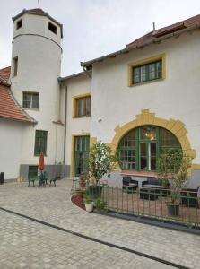 a large white building with a lighthouse in the background at Meller-kastély Villa in Csurgó