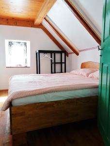 ein Schlafzimmer mit einem Bett im Dachgeschoss in der Unterkunft počitniška hiška MEDVEJKE in Slap ob Idrijci