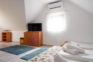 sala de estar con cama y TV en Szeparé pinceház szállás Villány központi részén., en Villány