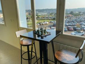 a table and two chairs in a room with a window at Superbe appartement avec vue panoramique sur Mers in Mers-les-Bains