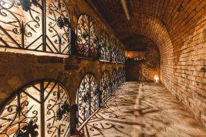 un callejón con puertas de hierro y una pared de ladrillo en Szeparé pinceház szállás Villány központi részén., en Villány