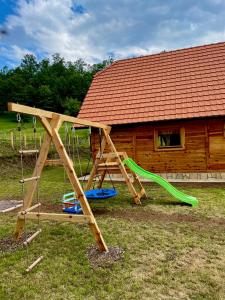 a playground with a slide and a swing at Mokrogorski konaci in Mokra Gora