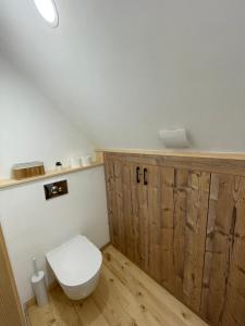 a bathroom with a white toilet and wooden walls at Mokrogorski konaci in Mokra Gora