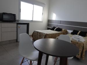 Habitación con mesa, 2 camas, mesa y sillas. en Urquiza, en Salta