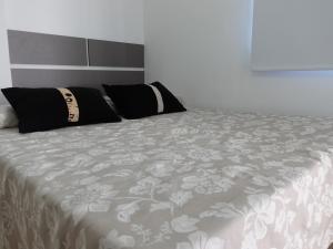 una cama con dos almohadas encima en Urquiza, en Salta