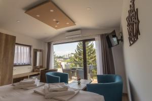 a room with a table and chairs and a large window at Verdi Rooms in Visoko