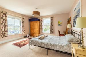 a bedroom with a bed and two windows at Cabbell Towers - Norfolk Holiday Properties in Cromer