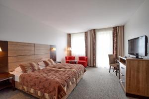 a hotel room with a bed and a flat screen tv at Diva Resort in Kołobrzeg +25 photos