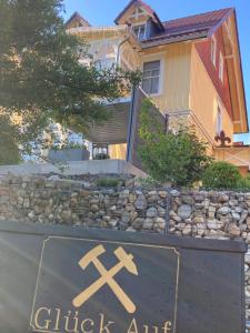 ein Haus mit einem Schild vor einer Felswand in der Unterkunft Villa Pusteblume in Bad Grund