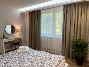 a bedroom with a bed and a desk and a window at Apartament Stylowy 2 in Leszno