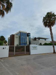 a building with a fence and a palm tree at L'APPARTAMENTO DEL MARE in Marsala