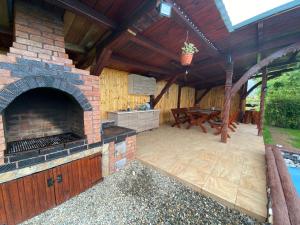 an outdoor patio with a brick oven and a table at Pensiunea Denis in Cârțișoara