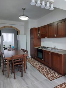 a kitchen with a wooden table and a dining room at L'APPARTAMENTO DEL MARE in Marsala